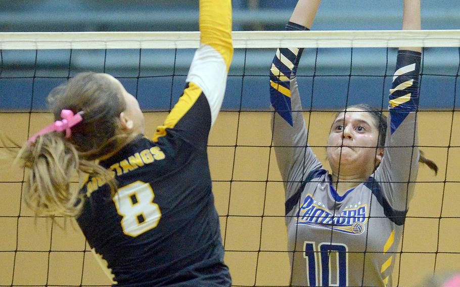 American School In Japan's Lilia Dow-Yuzawa skies for a spike against Yokota's Adrianna Diaz during Thursday's three-set win by the Mustangs.