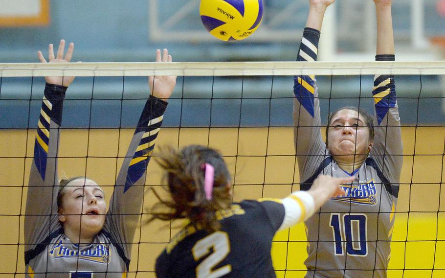 American School In Japan's Aloha Suto slams a spike between the block of Yokota's Madison Eaton and Adrianna Diaz during Thursday's three-set win by the Mustangs.