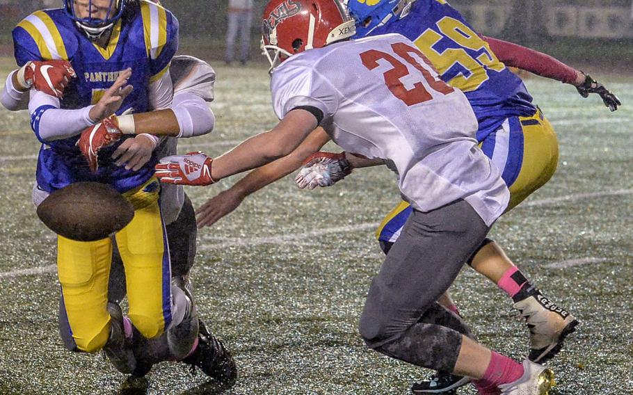 Yokota quarterback Ethan Gaume has the ball knocked out of his hands by the Nile C. Kinnick defense.