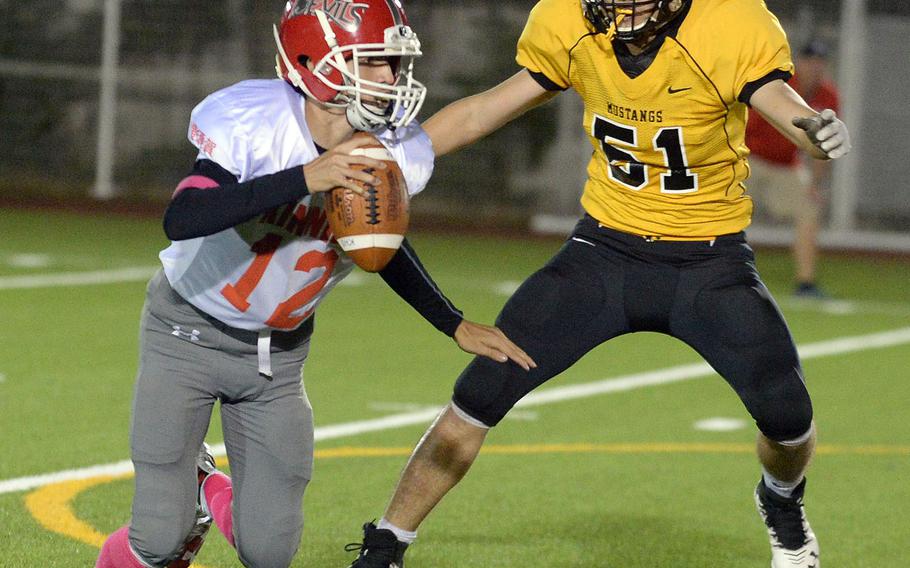 Nile C. Kinnick quarterback Patrick Kelly tries to elude American School In Japan defender Yamato Hill, who had a punt block, a sack and a fumble recovery in Friday's game.