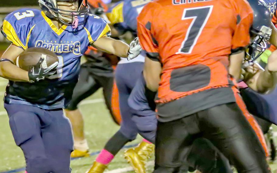 Guam High running back Julius Gaduang approaches the line and Okkodo defender Geronimo Limes.