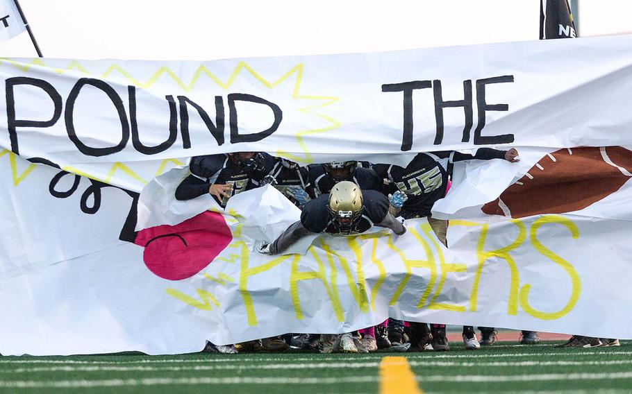 Humphrey football players bust through a sign before a game with Kadena, at Camp Humphreys, South Korea, Saturday, Oct. 13, 2018. 