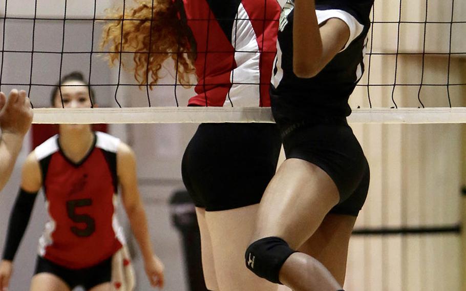 E.J. King's Kathryn Stougard and Matthew C. Perry's Bryana McPhail battle at the net for the ball during Thursday's match in the DODEA Japan girls volleyball tournament. The Cobras won in four sets.