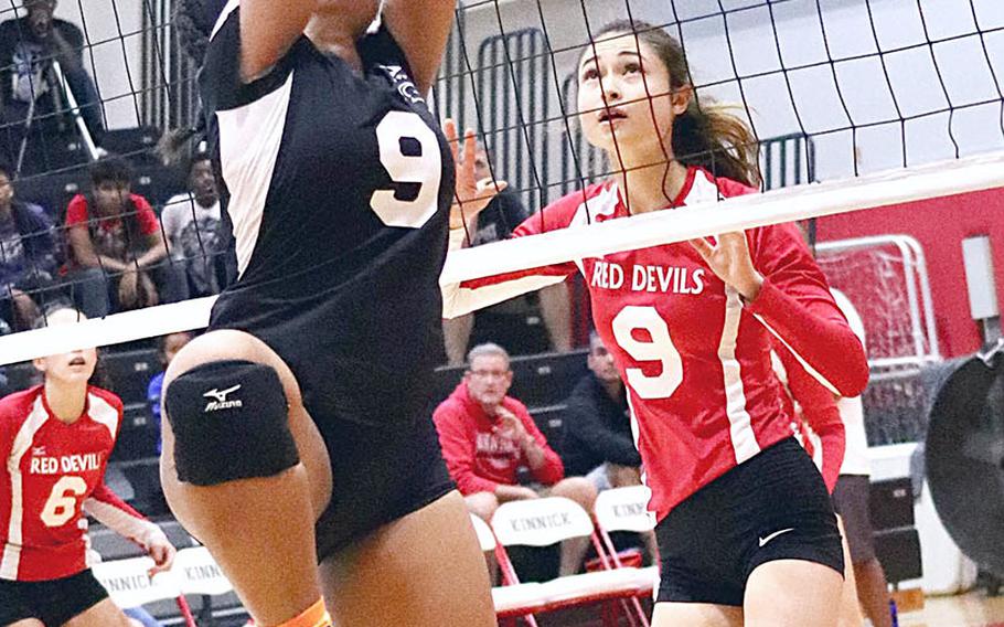 Zama's Grace Bryant plays the ball at the net against Nile C. Kinnick's Melissa Rose during Saturday's DODEA Japan girls volleyball tournament final. The Trojans rallied from one set down to beat host Nile C. Kinnick in four sets.