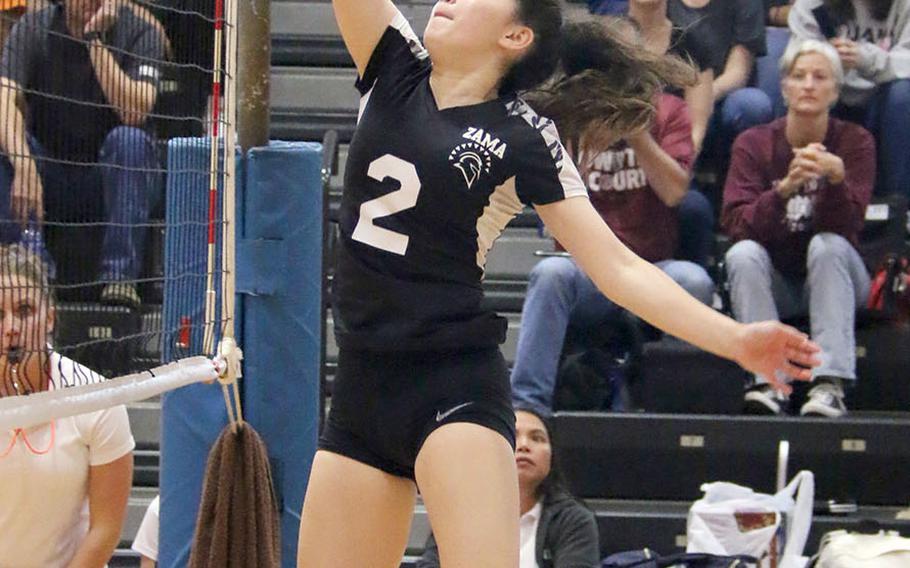 Zama's Jazlyn Rioux plays the ball at the net during Saturday's DODEA-Japan girls volleyball tournament final. The Trojans beat host Nile C. Kinnick in four sets.