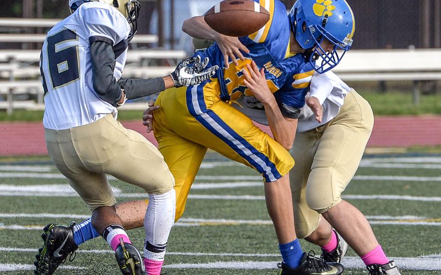 Yokota's Joseph Vasquez cannot hang onto the football as he's corraled by two Humphreys defenders.