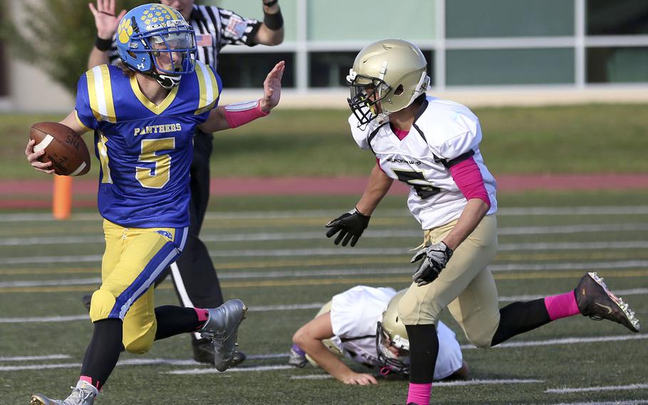 Yokota quarterback Ethan Gaume tries to elude Humphreys' Yob Yang.