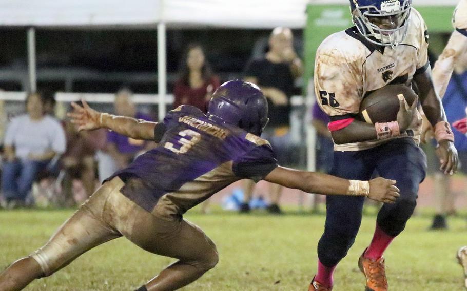 Guam High's Jeylyn Dowdell tries to avoid the tackle of George Washington's Jerome Quichocho.