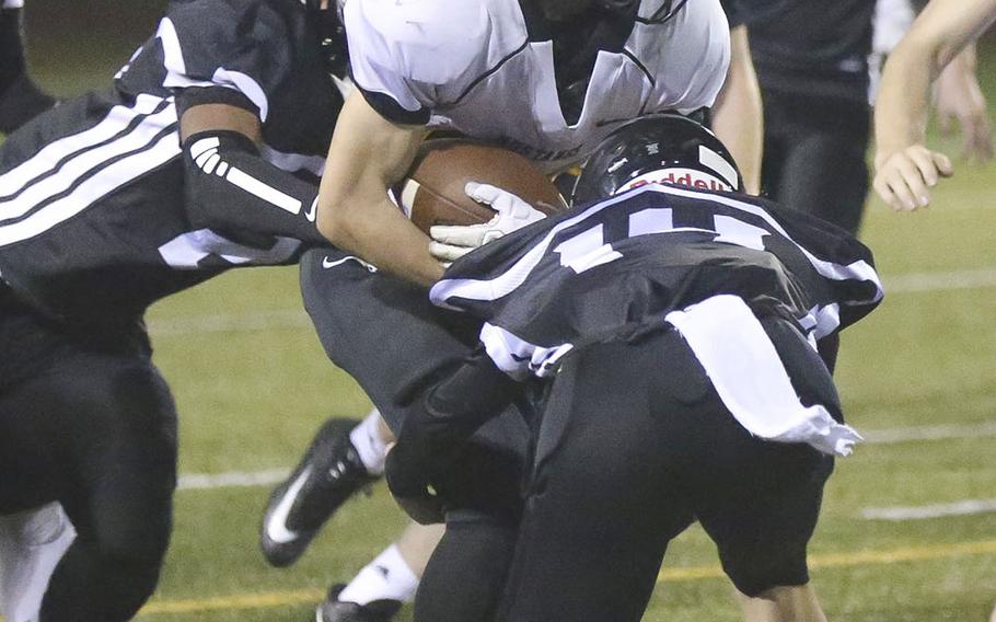 American School In Japan running back Allen Edmunds gets tackled by Zama's Dominic Peruccio and Keshawn McNeill.