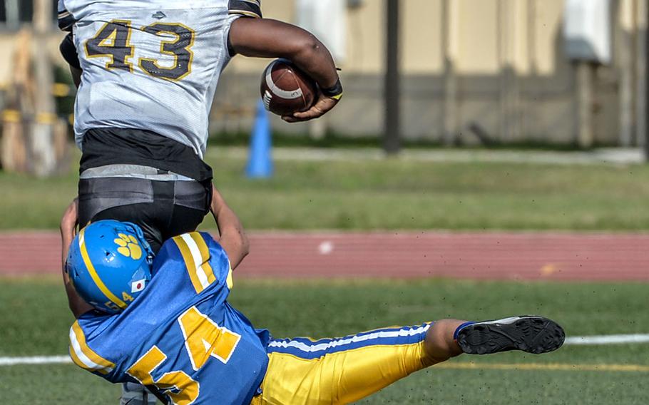 Kadena fullback Uriah Morris drags Yokota linebacker Joey DeGrella into the end zone.