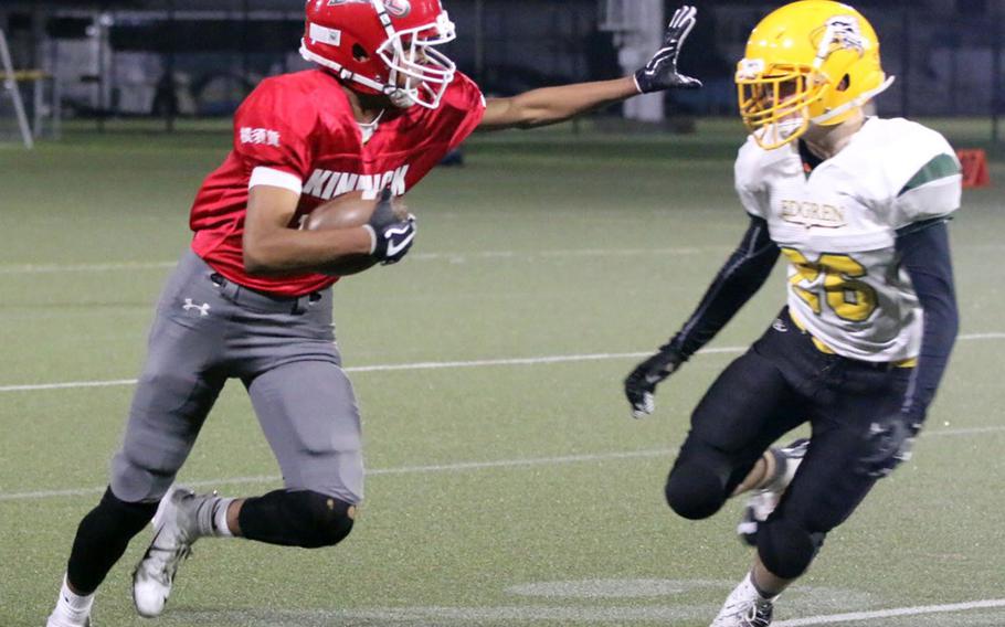 Kinnick receiver Kaine Roberts delivers a stiff arm as he dashes past Edgren defensive back Tyler Clarkson.