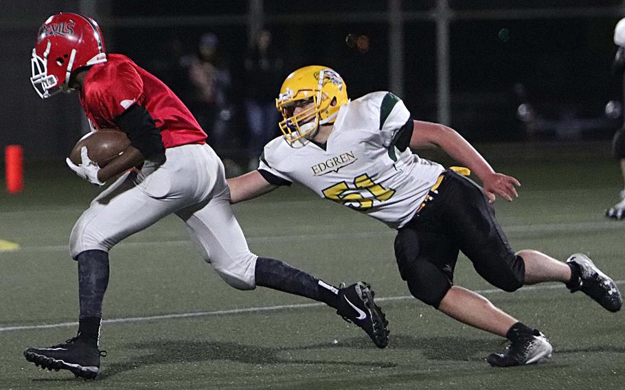 Kinnick ball carrier Jayden Jones tries to evade an outstretched Edgren would-be tackler Ethan Berry.
