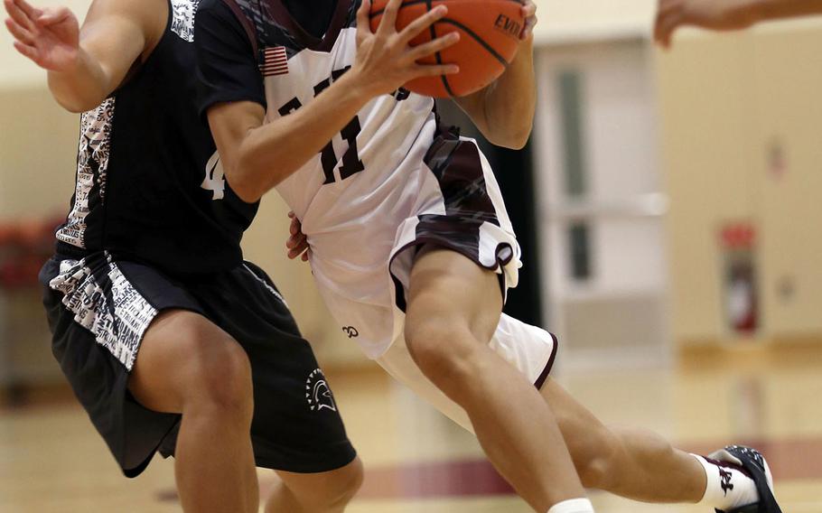 Matthew C. Perry's Anthony Laney drives for the basket against Zama during Friday's Japan boys basketball game. The Trojans won Friday's game 66-45, but the Samurai roared back on Saturday to beat Zama 60-51 and win two of three games they played over the weekend.