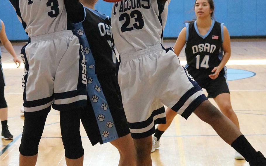 Seoul American's Lauren Kirschner and Tacoria Hickey collide as they vie for a rebound against Osan during Saturday's Korea girls basketball game. The Falcons rallied for a 44-39 win.