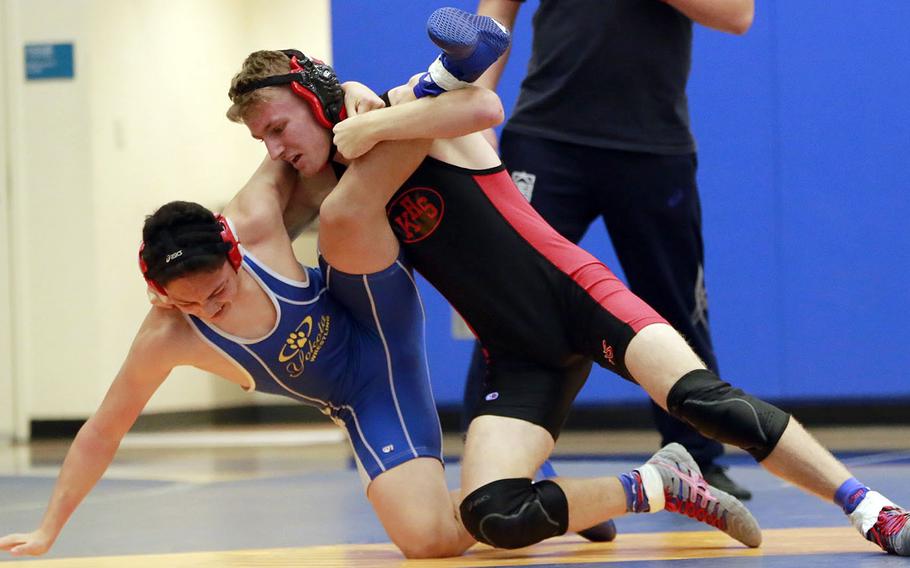 Nile C. Kinnick's Ethan Hamilton takes Yokota's Joey DeGrella to the mat during Saturday's Japan wrestling dual meet. Hamilton won by technical fall and the Red Devils won the dual meet 37-20.