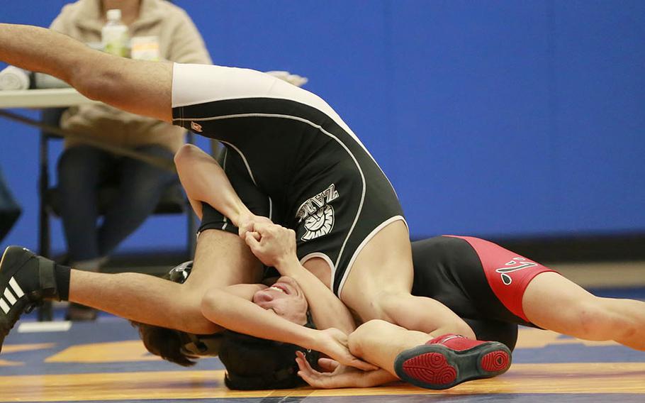 Nile C. Kinnick's Charlie Labato wrenches Zama's Angel Fuentes' shoulders to the mat during Saturday's Japan wrestling dual meet at Yokota. Labato pinned Fuentes and the Red Devils won the dual meet 54-0.