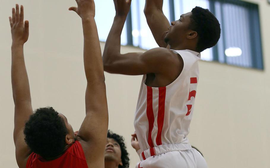E.J. King's Dyson Robinson skies for a shot between two Nile C. Kinnick defenders during Friday's Japan boys basketball game. The Cobras won 67-62 in a battle of unbeatens.