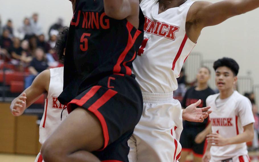 E.J. King's Dyson Robinson drives to the basket past Nile C. Kinnick's Rodrick Bell during Saturday's Japan boys basketball game. The Red Devils won 54-34, handing the Cobras their first loss in nine games this season.