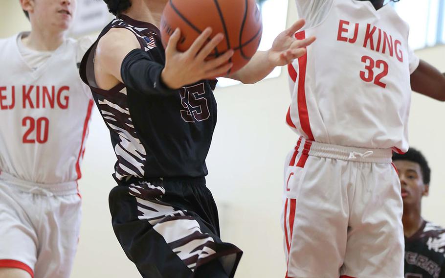 Matthew C. Perry's Gabriel Barrera tries to shoot against E.J. King's Chris Fizer during Saturday's Japan boys basketball game. The Cobras won 60-39.