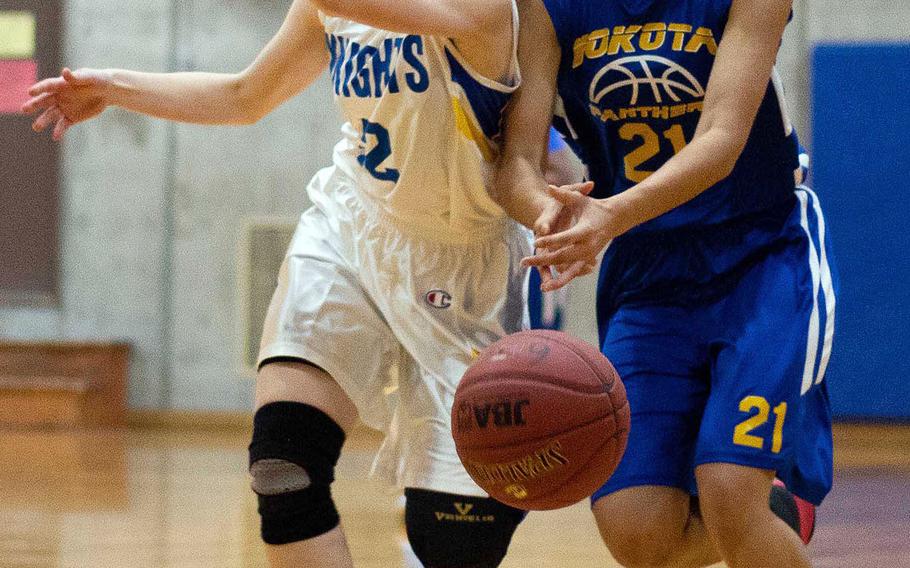 Yokota's Hana Robbins can't find the handle on the ball against Christian Academy Japan's Anna Stoesz during Saturday's Japan girls basketball game. The Panthers won 24-15.