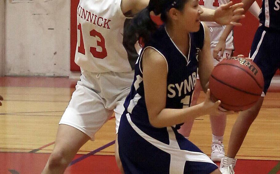 Nile C. Kinnick's Melissa Rose cuts off Sacred Heart's Karin Kosugi's path to the basket during Tuesday's Japan girls basketball game. The Red Devils won 41-34.