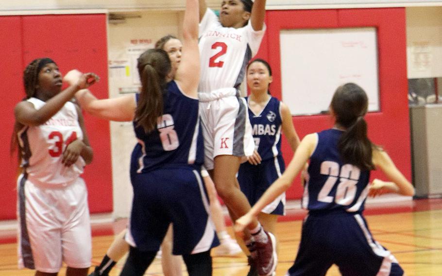 Nile C. Kinnick's Journey Hammond shoots over Sacred Heart defenders during Tuesday's Japan girls basketball game. The Red Devils won 41-34.