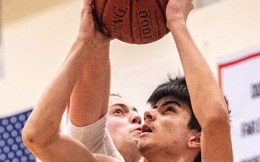 Yokota's Taylor Jenkins tries to block St. Mary's Alister Jones during Tuesday's Japan boys basketball game. The Titans won 43-24.
