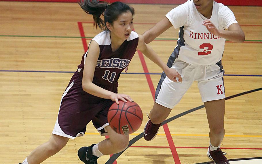 Seisen's Sarah Atanacio dribbles against Nile C. Kinnick's Journey Hammond during Thursday's Japan girls basketball game. The Phoenix won 34-30 in extra time.