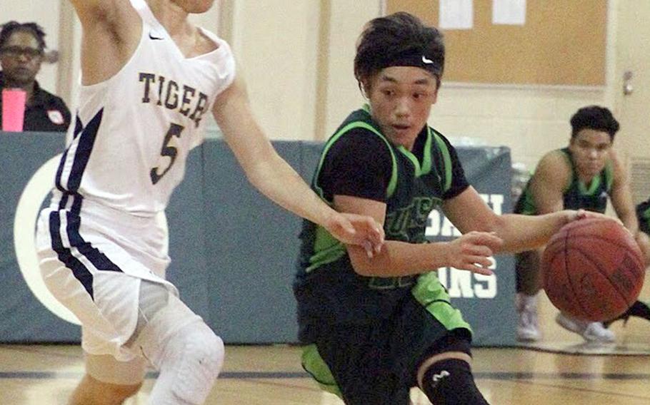 Kubasaki's Dylan Canlas drives against Taipei American during Sunday's Taipei Basketball Exchange boys game. The Tigers edged the Dragons 65-58.