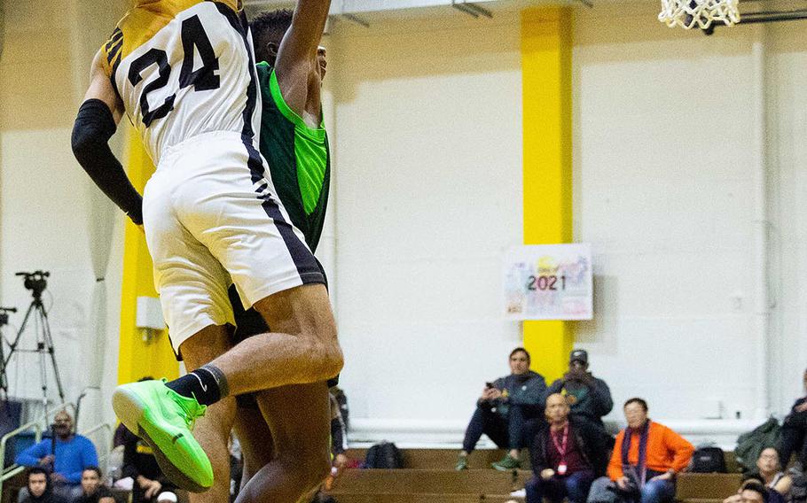 Humphreys' Quintin Metcalf leaps to make a shot over Kubasaki's Damien Dorval during Thursday's ASIJ Kanto Classic Tournament boys game, won by the Blackhawks 68-41.