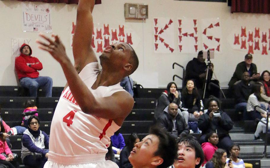 Nile C. Kinnick's Roderick Bell shoots over two St. Mary's defenders during Tuesday's Japan boys basketball game. The Red Devils won 51-30.