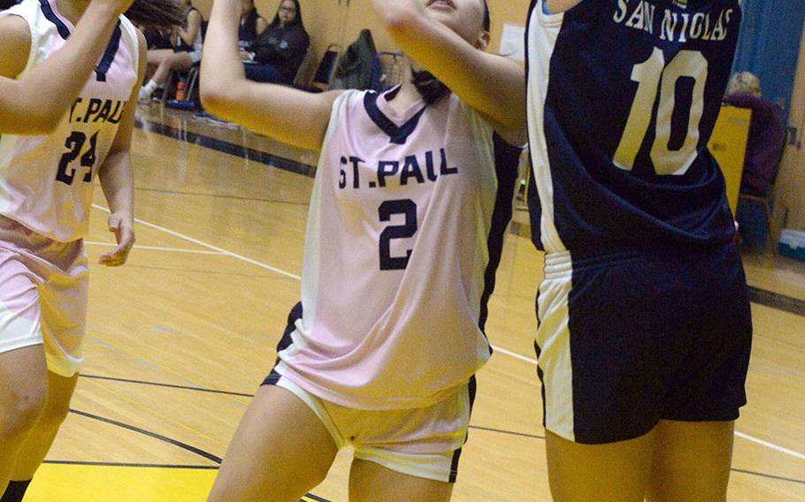 St. Paul Christian's Jan Quintanilla has her path to the basket blocked by Academy of Our Lady of Guam's Mia San Nicolas.