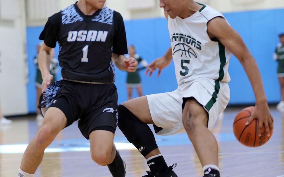 Daegu's Sam Murphy dribbles against Osan's Leo Legaspi during Saturday's Korea boys basketball game, won by the Cougars 67-57.