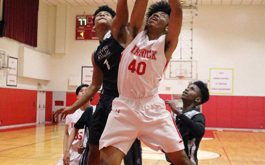 Nile C. Kinnick's Darryl Williams and Zama's Keshawn McNeil sky for a rebound during Tuesday's Japan boys basketball game. The Red Devils won 79-45.