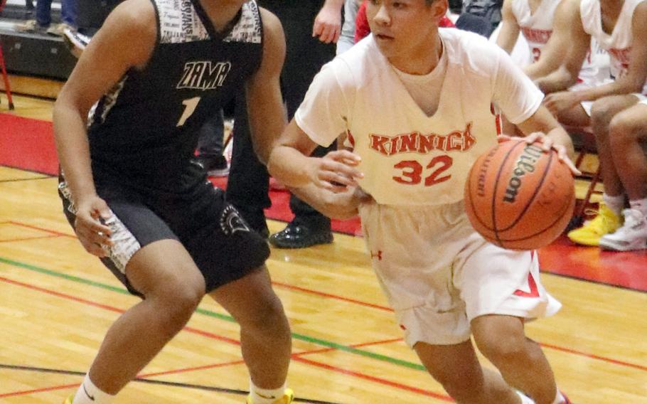 Nile C. Kinnick's Matthew Pardo drives against Zama's Keshawn McNeil during Tuesday's Japan boys basketball game. The Red Devils won 79-45.