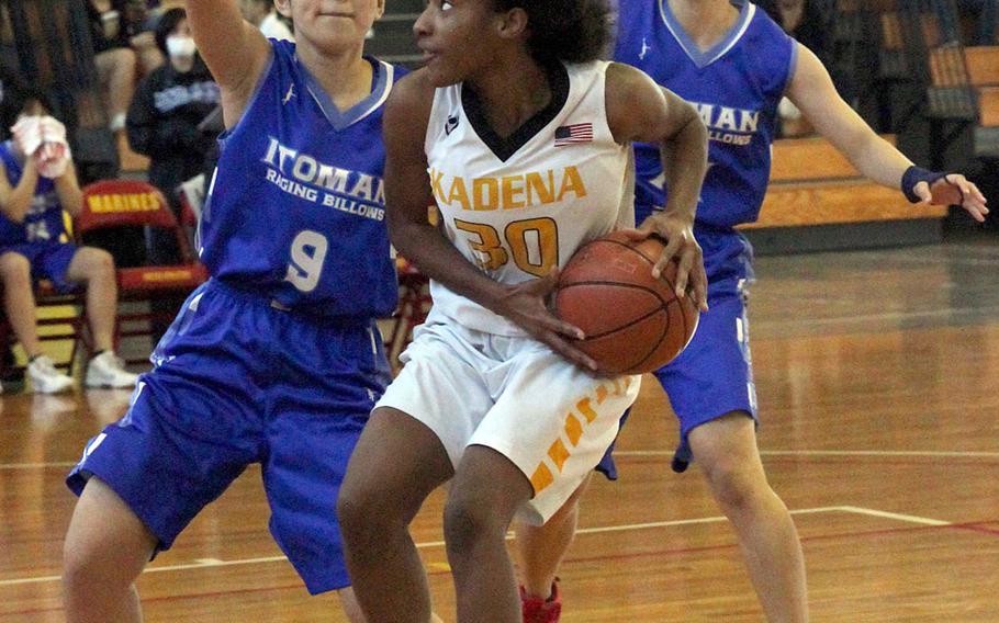 Kadena's Atirria Simms looks for room against two Itoman defenders on Day 1 Saturday of the 13th Okinawa-American Friendship Basketball Tournament. The Raging Billows routed the Panthers 72-37.