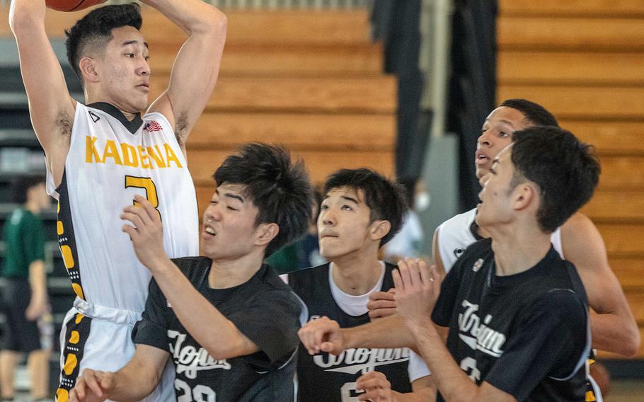 Kadena's Casey Cox towers over several Oroku defenders on Day 1 Saturday of the 13th Okinawa-American Friendship Tournament. The Panthers won 62-47.