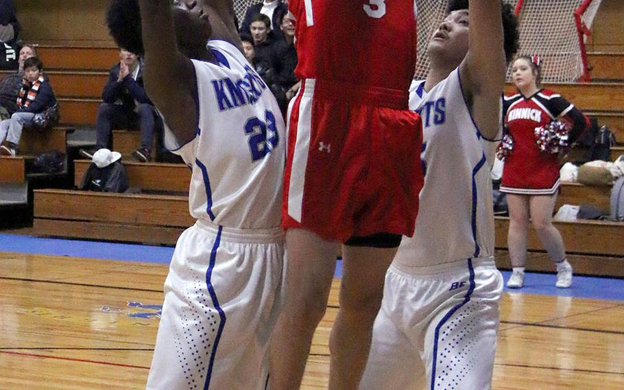 Nile C. Kinnick's Davion Roberts shoots against Christian Academy Japan's Enosh Mutenda during Tuesday's Japan boys basketball game. The Red Devils won 89-68.
