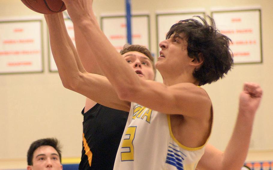Yokota's Jacob Hensley drives to the basket against American School In Japan's Oliver Rogers during Tuesday's Japan boys basketball game. The Mustangs won 53-36 on Yokota's senior night.