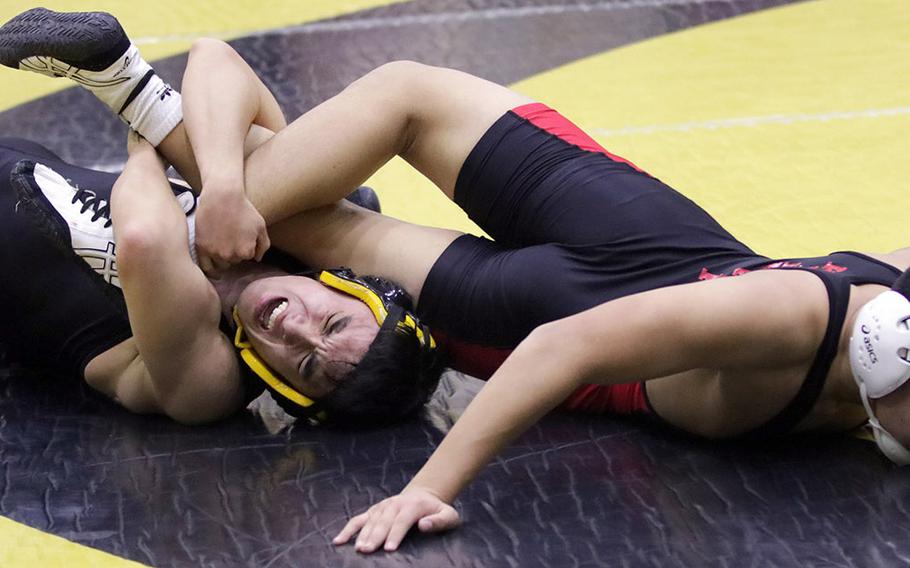 American School In Japan's Kieran Kell employs a leg lace against Nile C. Kinnick's Kaleb Leon Guerrero at 158 pounds during Tuesday's Japan wrestling dual meet. Kell won by technical fall 16-6 and the Mustangs won the meet 42-20.