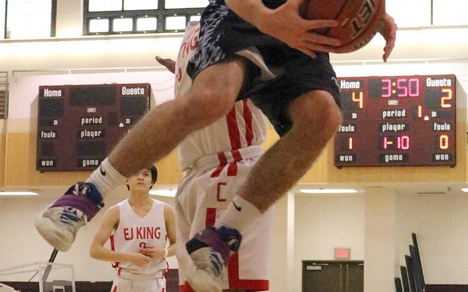 Osan's Joey Betts leaps with the ball against E.J. King during Thursday's Far East Division II pool-play game. The Cobras won 47-34.