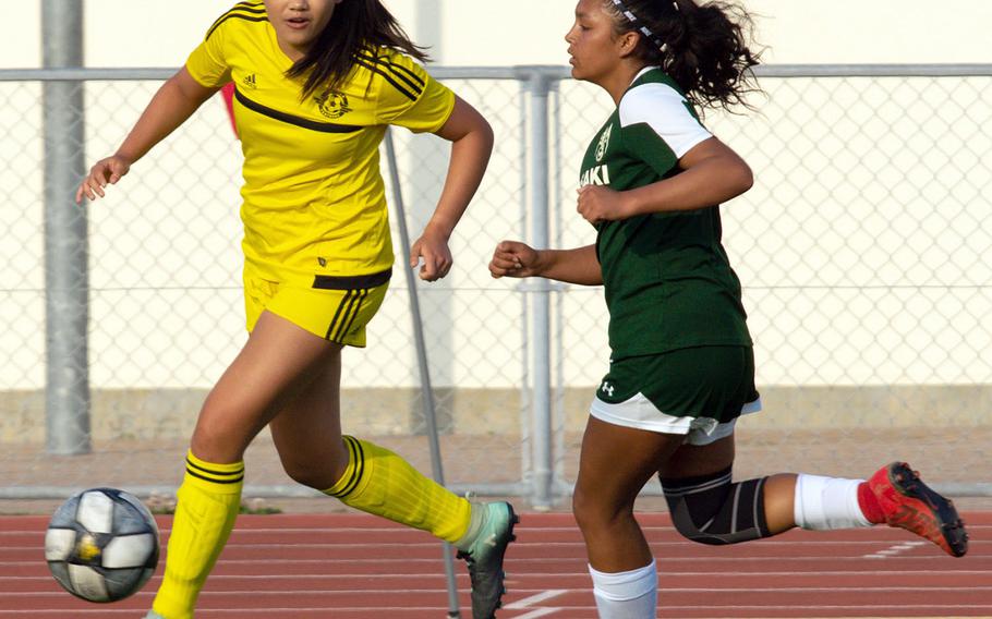 Kadena's Trinity Hannaway outruns Kubasaki's Chloe Ibarra for the ball during Wednesday's Okinawa girls soccer match, won by the Panthers 7-1.