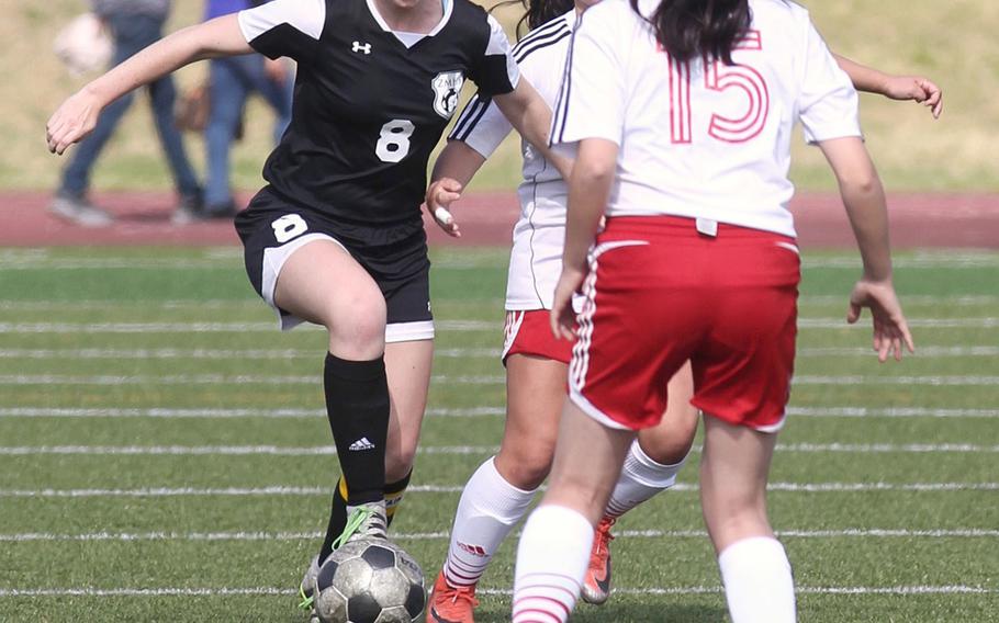 Zama's Siobhan Grabski sizes up a run between two Nile C. Kinnick defenders during Saturday's DODEA-Japan girls soccer tournament final. The Red Devils won 4-0.