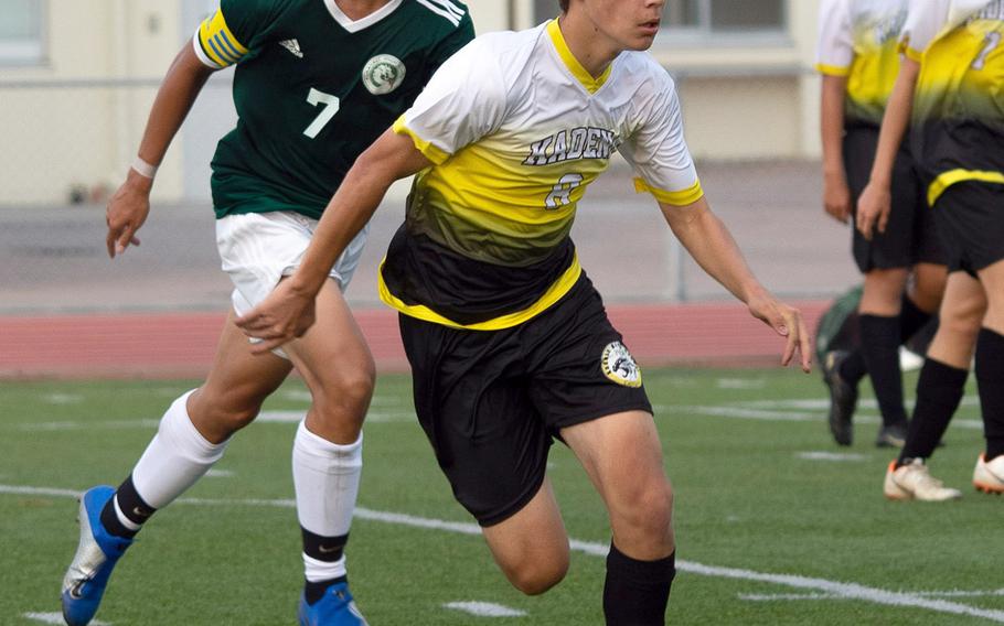 Kadena's Sean Fletcher and Kubasaki's Sinjin Pharathikoune chase the ball during Wednesday's Okinawa boys soccer match. The teams battled to a 2-2 draw.