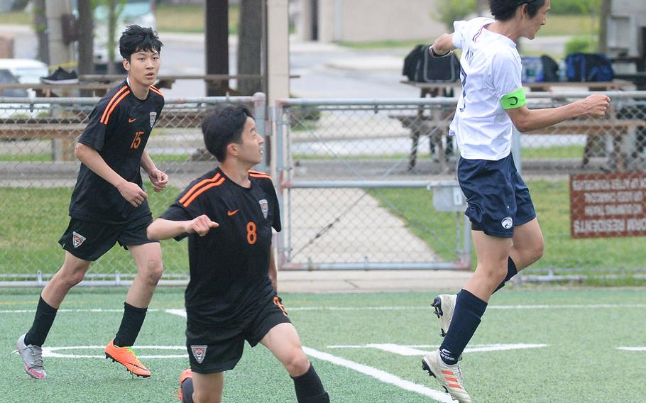 Osan's Minsung Kim heads the ball in front of Seoul International's Eddie Hahm and Archie Lee during Friday's Korea boys soccer Plate Tournament at Osan Air Base. The host Cougars won 3-0.