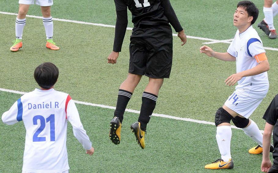 Daegu's Sam Murphy heads the ball, surrounded by International Christian-Pyongtaek players, during Friday's Korea boys soccer Plate Tournament match at Osan Air Base. The Conquerors won 3-1.