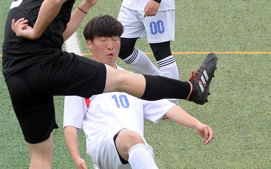 Daegu's MIciah Ruff leaps up to kick the ball against International Christian-Pyongtaek's Don Lee during Friday's Korea boys soccer Plate Tournament match at Osan Air Base. The Conquerors won 3-1.