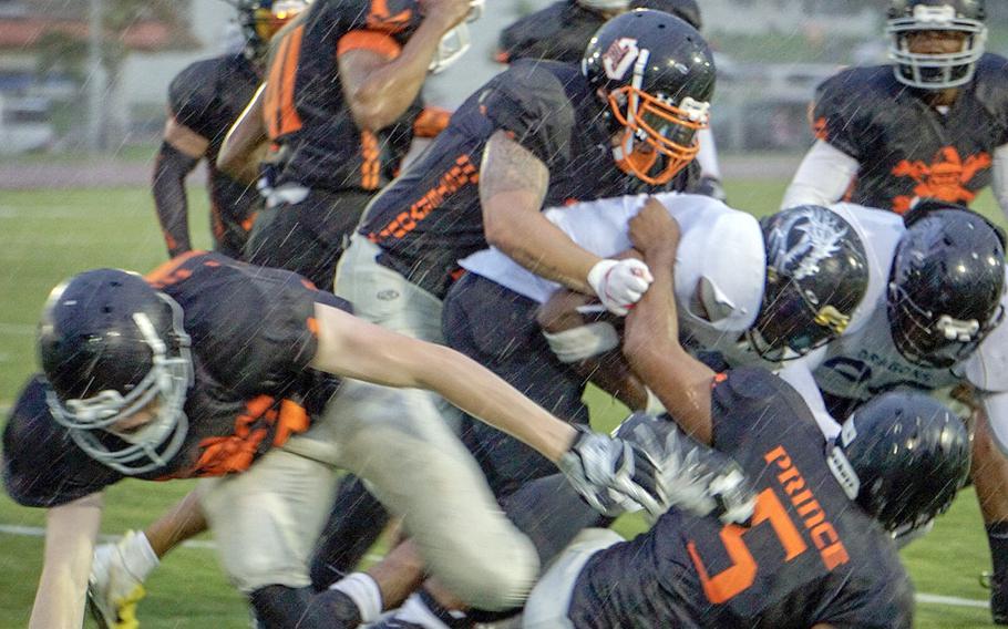Hansen's Caine Collins leads a pack of Hansen Outlaws defenders, bringing down an Okinawa Dragons ballcarrier in the driving rain of the second quarter of the Torii Bowl.