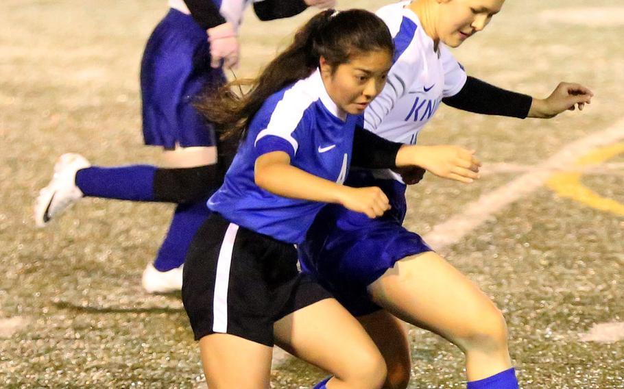 Christian Academy Japan's Maika Edberg and Yokota's Emma Oshiro chase the ball with Knights teammate Kaitlyn Corbett in trail above during Tuesday's Japan girls soccer match, won by the Panthers 2-0.