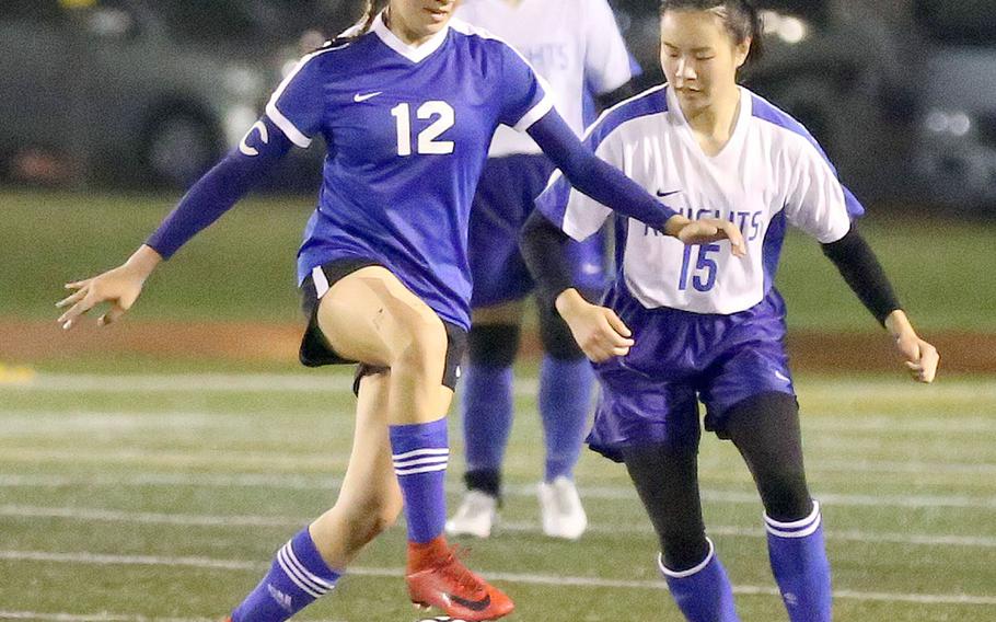 Yokota's Chloe Dozier works the ball against Christian Academy Japan's Keziah Sou during Tuesday's Japan girls soccer match, won by the Panthers 2-0.